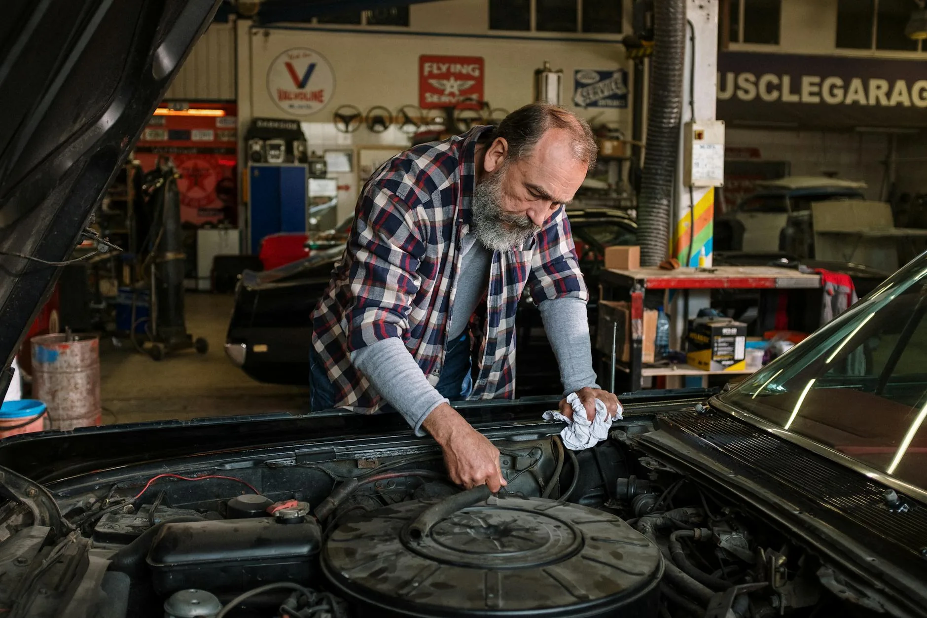 Bearded mechanic working on engine repair in auto repair shop