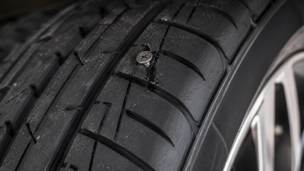 Self-sealing car tyre with a nail in the tread that has sealed and kept the tyre inflated